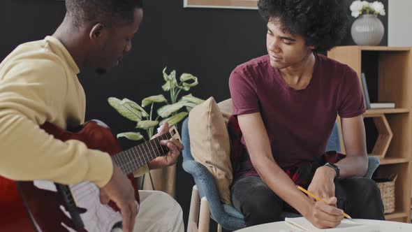 Young Man Learning to Play Guitar