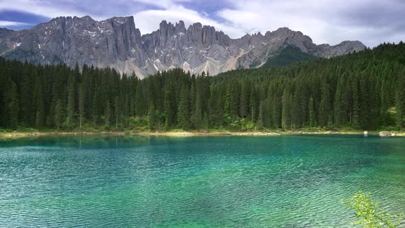 Karersee Lake or Lago Di Carezza, Italy. Wind Blowing on Waters of the Lake. A Pine Forest