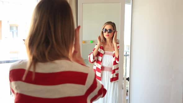 Young girl dressing up near a mirror for vacation