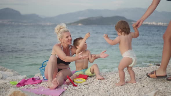 Grandma Playing with Children on the Beach By the Sea