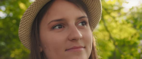 Portrait of a young woman with hat looking away, feeling happy and relaxed 