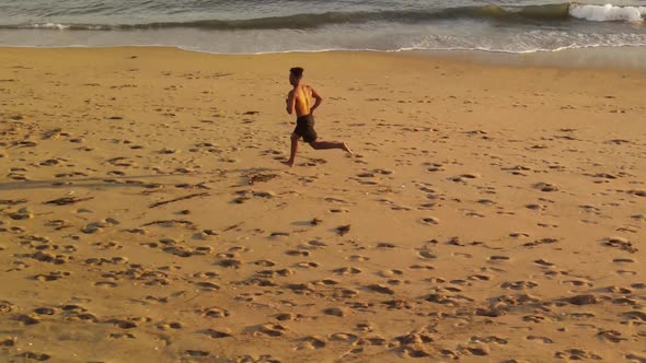 Aerial shot of a man jogging on the beach