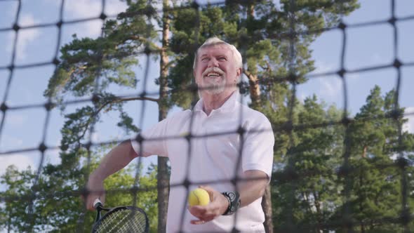 Portrait Joyful Happy Smiling Mature Man Playing Tennis on the Tennis Court
