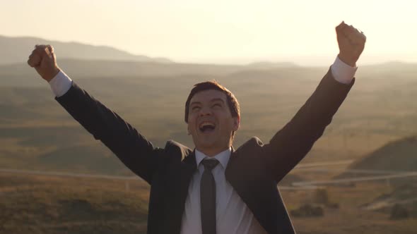 Cheerful Businessman Celebrating Victory on Nature