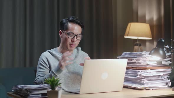 Asian Man Explaining Work While Having Video Call On Laptop At Home