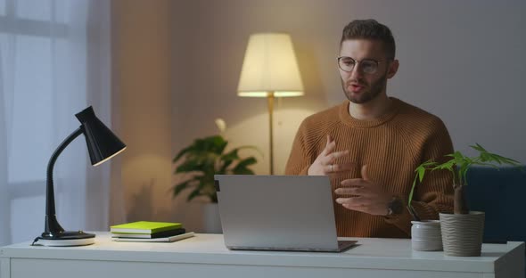 Young Man Dressed Brown Sweater Is Welcoming Interlocutors on Working Video Chat Online Conference