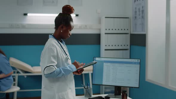 Black Doctor Looking at Digital Tablet for Appointment