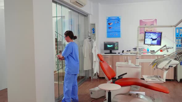 Nurse Inviting Patient in Stomatology Room Showing to Lie on Chair