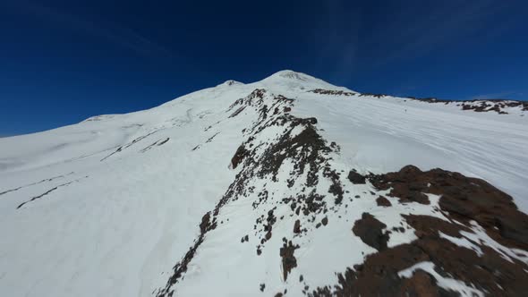 Aerial Fpv Drone View Flying to High Mountain Peak with Skiing Trace with Ski and Snowboard People