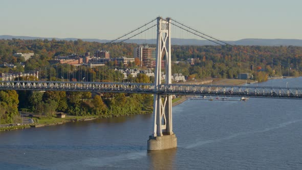 Aerial of Mid-Hudson Bridge and town amidst autumn trees at distance