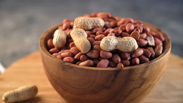 Raw Peanuts in small wooden bowl on natural gray rustic desk Video 4k