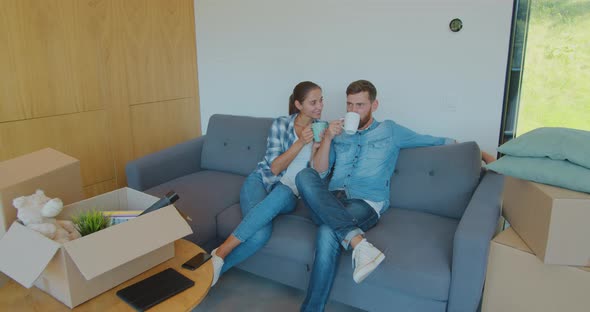 Panning Waist-up Shot of Pleased Smiling Caucasian Husband and Wife Relaxing and Drinking Tea