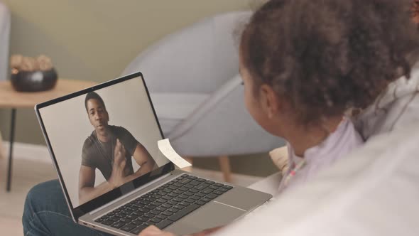 Woman and Little Girl Video Chatting with Soldier Father on Laptop alt
