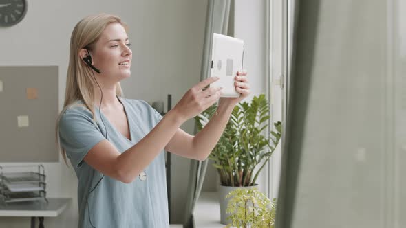 Girl Using Tablet by Window