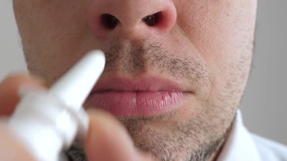 Sick Man Applying Medicine Spray Into His Nose