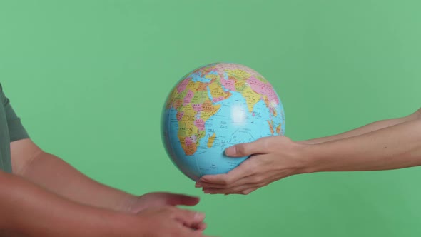 Close Up Of Men's Hands Hand In The World Globe To Each Other On The Green Screen Background