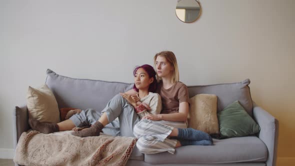 Young Diverse Women Sitting on Sofa and Embracing