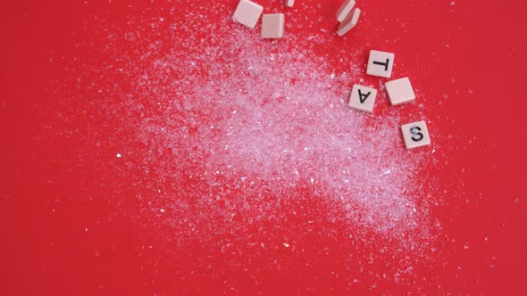 White letter tiles moving to spell out christmas on glitter on red background