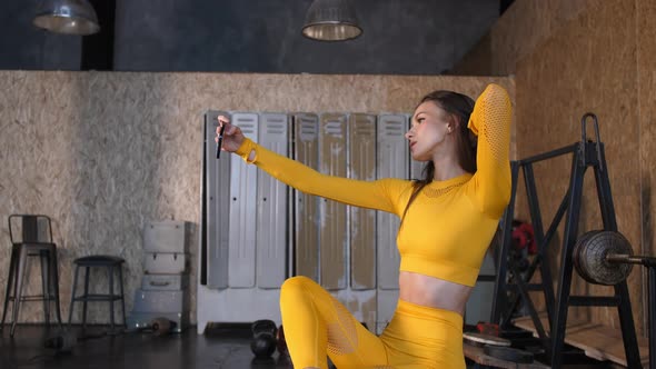 Girl Athlete Makes a Selfie in the Gym