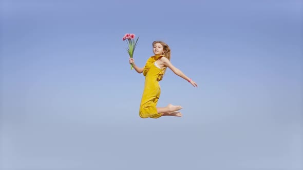 Girl in Jump in Slow Motion with Flowers in Hand