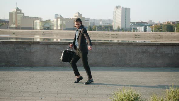 Dance Loop of Confident Guy in Suit Dancing Outdoors in River Embankment in Modern City