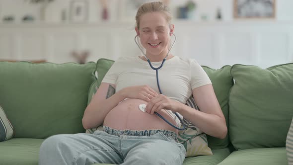Happy Pregnant Woman Listening Her Big Tummy with Stethoscope