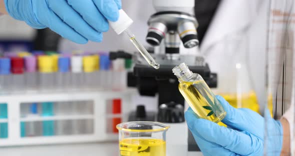 Gloved Scientist Drips Marijuana Oil Into Glass Beaker in Laboratory  Movie