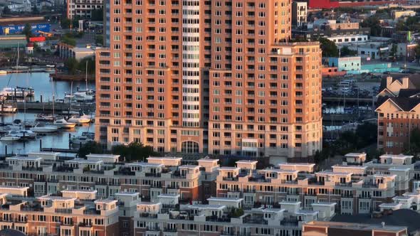 Tall apartment building in urban American city. Waterfront apt views. Rising aerial, long zoom.