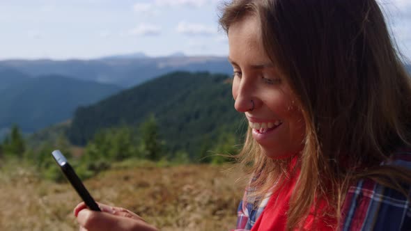 Girl Using Smartphone in Mountains