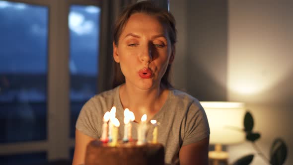 Happy Excited Woman Making Cherished Wish and Blowing Candles on Holiday Cake Celebrating Birthday