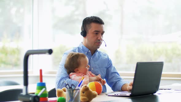 Father with Baby Working on Laptop at Home Office