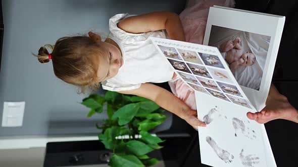 Happy Cute Little Girl Looking at Photos in Album