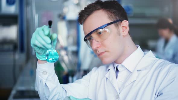 Young Scientist Checking Test Tubes in the Lab alt