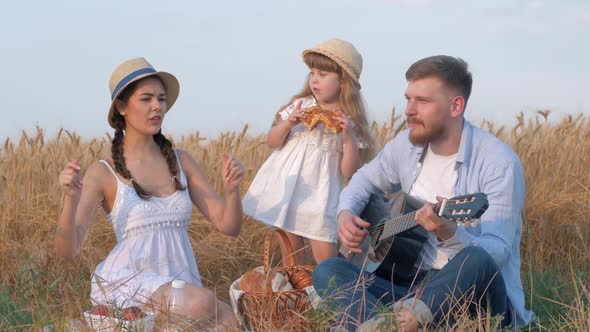 Family Countryside Recreation, Young Dad Plays Guitar When His Beautiful Woman in Straw Hat and