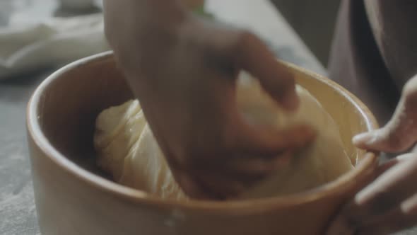 Female Hands Kneading Dough in Bowl