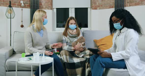 Doctor Visiting Her Teen Patient at Home while that is ill and Listening Mother 