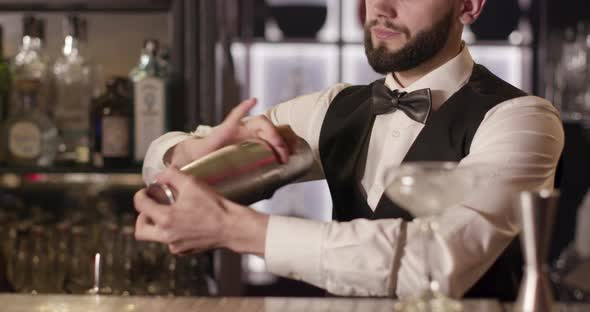 Close-up Shooting. The Bartender Is Mixing a Drink in a Shaker. 