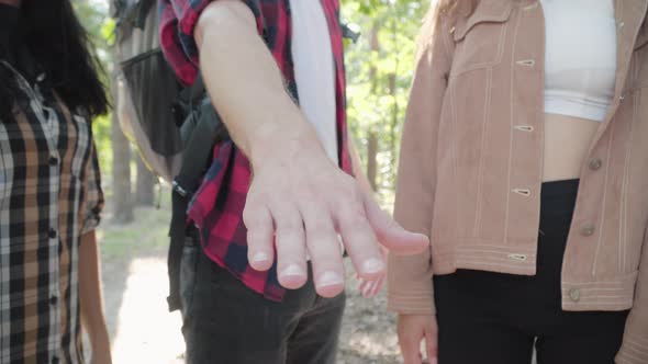 Close-up of Unrecognizable Caucasian Friends Stacking Hands in Sunny Forest Outdoors. Group of
