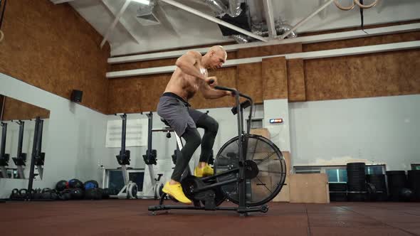 Strong athlete doing cardio workout on air bike