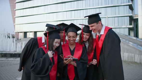 Graduation at an International University Young People in Graduate Robes Standing Near the