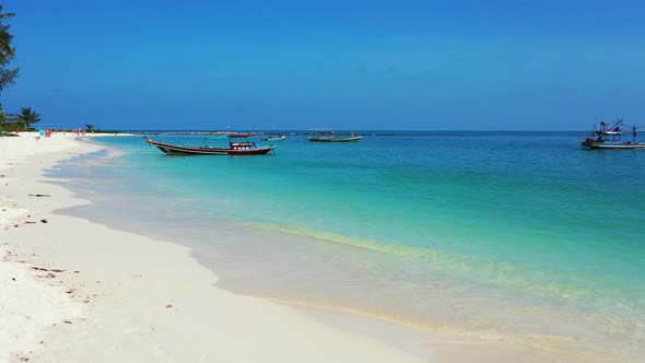 Natural fly over tourism shot of a sunshine white sandy paradise beach and turquoise sea background 