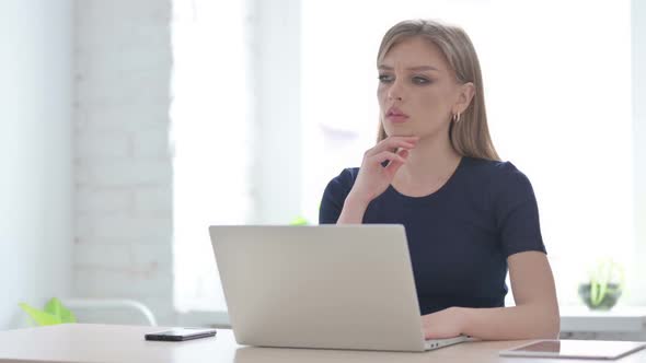 Woman Thinking While Working on Laptop