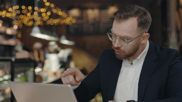 Angry Businessman Arguing in Video Chat at the Cafe