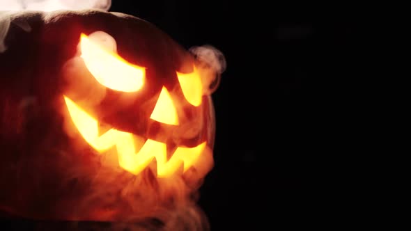 Shining Jack-O-Lantern. Halloween Pumpkin with Scary Face Smoke Inside with Flame Isolated 