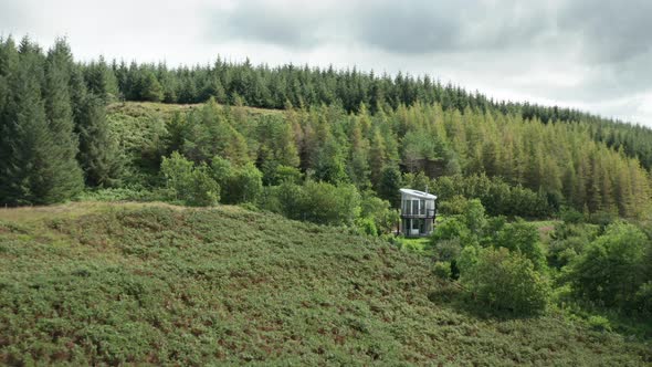 AERIAL ESTABLISHING - a contemporary aluminum house is found nestled in a forest