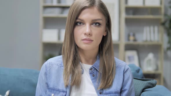 Portrait of Serious Young Girl Looking at Camera