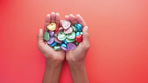 Heart Shape Candy on Hand on Red Background