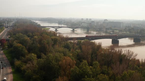 Two Passenger Trains Passing By Each Other on Railway Bridge Spanning Wide Vistula River