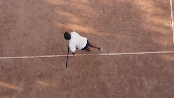 Aerial Top Down View of Young Man Serves and Hits Ball Jumping on Court