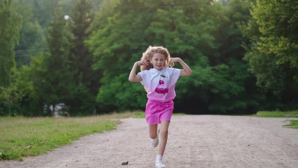 Happy girl run in summer park. Small child running with flying hair in motion